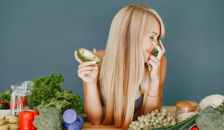 mujer preparando una ensalada con el pelo fuerte y sano.